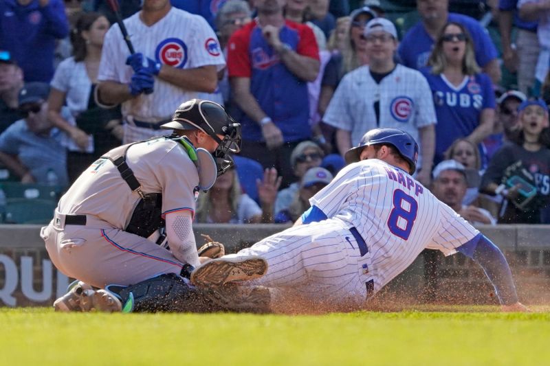 May 7, 2023; Chicago, Illinois, USA; Miami Marlins catcher Nick Fortes (4) tags out Chicago Cubs left fielder Ian Happ (8) at home plate during the eleventh inning at Wrigley Field. Mandatory Credit: David Banks-USA TODAY Sports