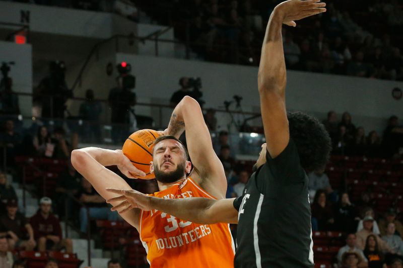 Jan 17, 2023; Starkville, Mississippi, USA; Tennessee Volunteers forward Uros Plavsic (33) collects a rebound as Mississippi State Bulldogs forward Tolu Smith (1) defends during the first half at Humphrey Coliseum. Mandatory Credit: Petre Thomas-USA TODAY Sports