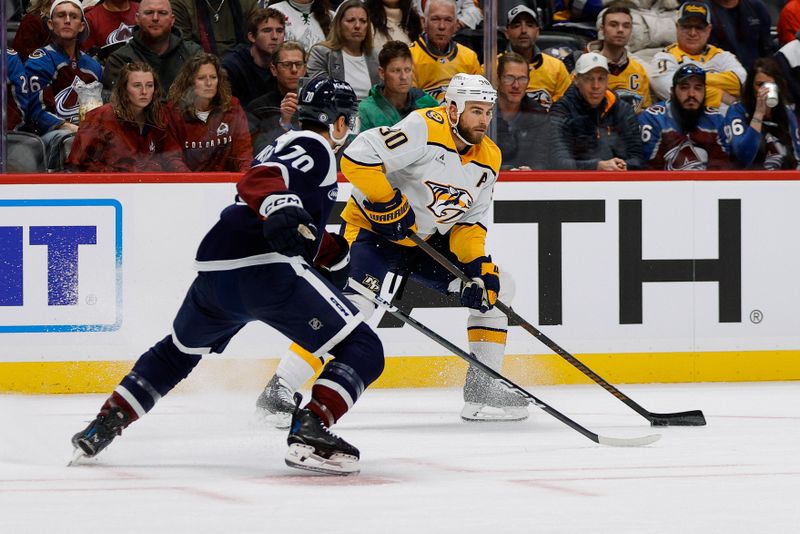 Dec 14, 2024; Denver, Colorado, USA; Nashville Predators center Ryan O'Reilly (90) controls the puck as Colorado Avalanche defenseman Sam Malinski (70) defends in the first period at Ball Arena. Mandatory Credit: Isaiah J. Downing-Imagn Images