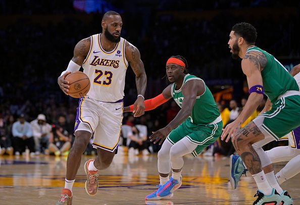 LOS ANGELES, CALIFORNIA - DECEMBER 25: LeBron James #23 of the Los Angeles Lakers is guarded by Jrue Holiday #4 and Jayson Tatum #0 of the Boston Celtics at Crypto.com Arena on December 25, 2023 in Los Angeles, California. NOTE TO USER: User expressly acknowledges and agrees that, by downloading and or using this photograph, User is consenting to the terms and conditions of the Getty Images License Agreement.(Photo by Jayne Kamin-Oncea/Getty Images)