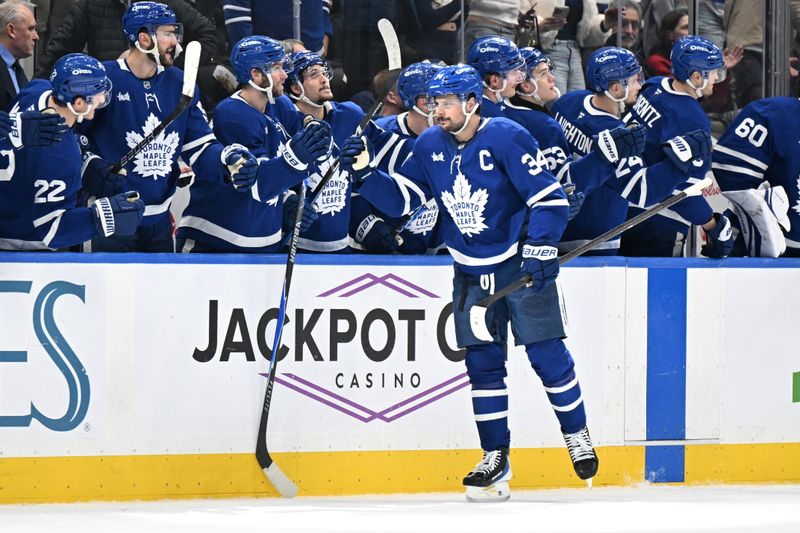 Jan 1, 2026; Toronto, Ontario, CAN;   Toronto Maple Leafs forward Auston Matthews (34) celebrates with team mates at the bench after scoring a goal against the Winnipeg Jets in the second period at Scotiabank Arena. Mandatory Credit: Dan Hamilton-Imagn Images
