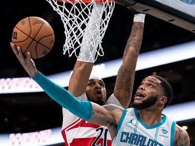 CHARLOTTE, NORTH CAROLINA - NOVEMBER 22: Miles Bridges #0 of the Charlotte Hornets drives to the basket while guarded by Daniel Gafford #21 of the Washington Wizards in the third quarter during their game at Spectrum Center on November 22, 2023 in Charlotte, North Carolina. NOTE TO USER: User expressly acknowledges and agrees that, by downloading and or using this photograph, User is consenting to the terms and conditions of the Getty Images License Agreement. (Photo by Jacob Kupferman/Getty Images)