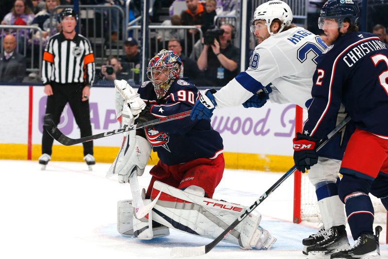 Nov 21, 2024; Columbus, Ohio, USA; Columbus Blue Jackets goalie Elvis Merzlikins (90) makes a glove save as Tampa Bay Lightning left wing Brandon Hagel (38) looks for a rebound during the first period at Nationwide Arena. Mandatory Credit: Russell LaBounty-Imagn Images