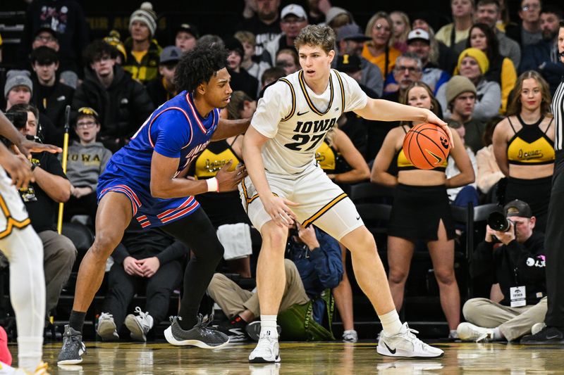 Dec 29, 2025; Iowa City, Iowa, USA; Iowa Hawkeyes center Trevin Jirak (27) controls the ball as UMass Lowell River Hawks forward Austin Green (10) defends during the first half at Carver-Hawkeye Arena. Mandatory Credit: Jeffrey Becker-Imagn Images