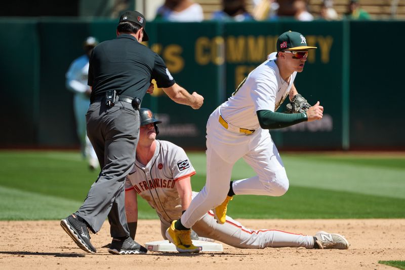 Aug 18, 2024; Oakland, California, USA; Oakland Athletics infielder Zack Gelof (20) runs to the dugout after tagging out San Francisco Giants infielder Tyler Fitzgerald (49) at second base as umpire David Rackley (86) makes the call during the sixth inning at Oakland-Alameda County Coliseum. Mandatory Credit: Robert Edwards-USA TODAY Sports