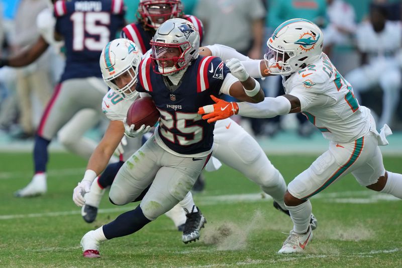 Miami Dolphins fullback Alec Ingold (30) and safety Elijah Campbell (22) go after New England Patriots cornerback Marcus Jones (25) during the second half of an NFL football game, Sunday, Nov. 24, 2024, in Miami Gardens, Fla. (AP Photo/Lynne Sladky)