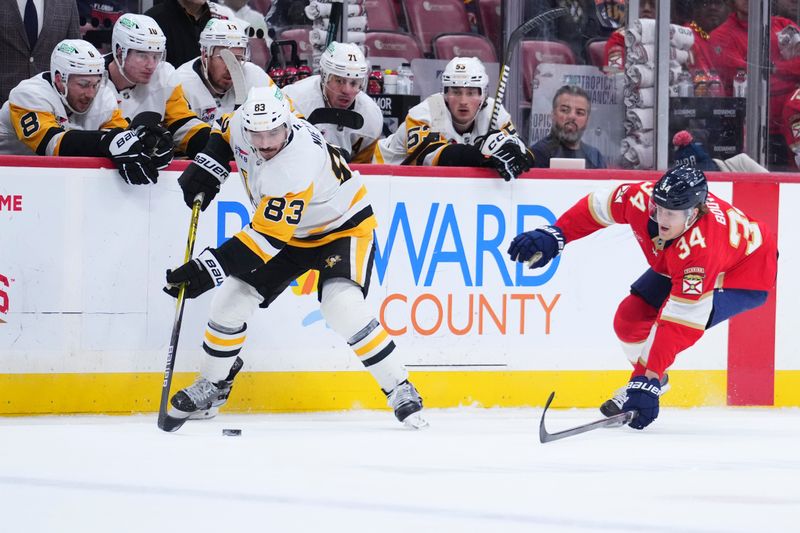 Jan 3, 2025; Sunrise, Florida, USA; Pittsburgh Penguins left wing Matt Nieto (83) controls the puck against Florida Panthers defenseman Adam Boqvist (34) during the first period at Amerant Bank Arena. Mandatory Credit: Rich Storry-Imagn Images