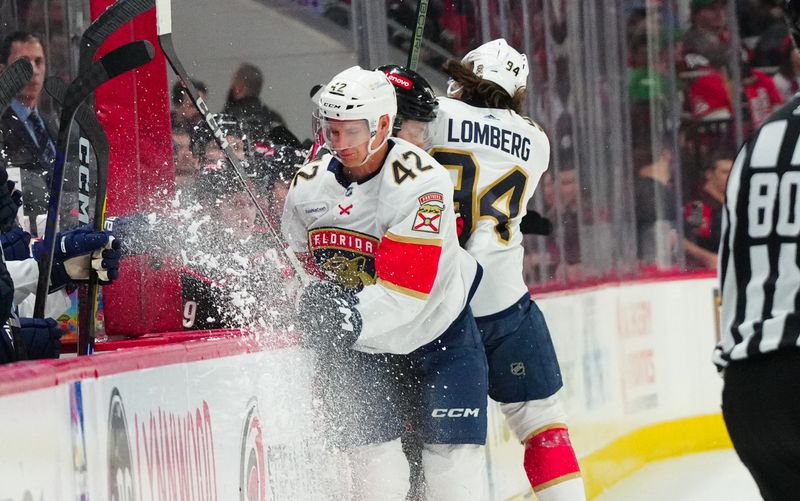 Mar 14, 2024; Raleigh, North Carolina, USA; Florida Panthers left wing Ryan Lomberg (94) and Florida Panthers defenseman Gustav Forsling (42) checks Carolina Hurricanes right wing Jesper Fast (71) during the first period at PNC Arena. Mandatory Credit: James Guillory-USA TODAY Sports