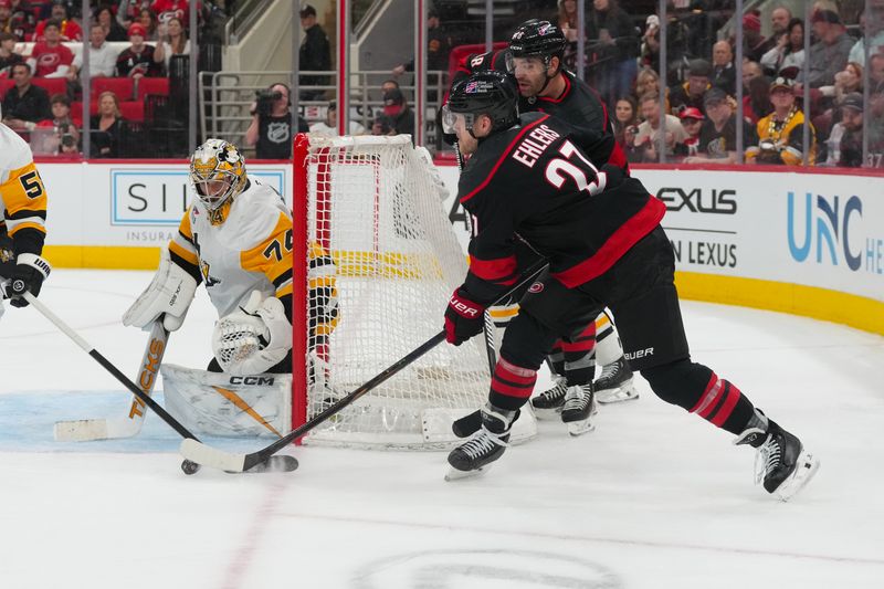 Mar 10, 2026; Raleigh, North Carolina, USA;  Carolina Hurricanes left wing Nikolaj Ehlers (27) gets the shot away towards Pittsburgh Penguins goaltender Stuart Skinner (74) during the third period at Lenovo Center. Mandatory Credit: James Guillory-Imagn Images