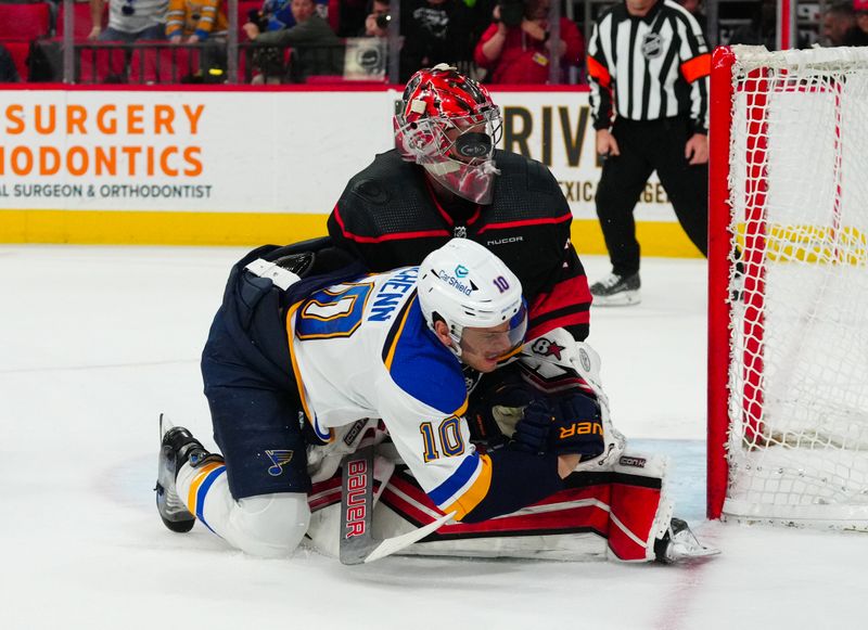 Jan 6, 2024; Raleigh, North Carolina, USA; Carolina Hurricanes goaltender Antti Raanta (32) stops the scoring attempt by St. Louis Blues center Brayden Schenn (10) during the overtime t PNC Arena. Mandatory Credit: James Guillory-USA TODAY Sports