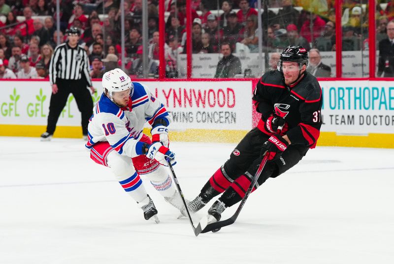 May 16, 2024; Raleigh, North Carolina, USA; Carolina Hurricanes right wing Andrei Svechnikov (37) tries to cuts with the puck past New York Rangers left wing Artemi Panarin (10) during the first period in game six of the second round of the 2024 Stanley Cup Playoffs at PNC Arena. Mandatory Credit: James Guillory-USA TODAY Sports