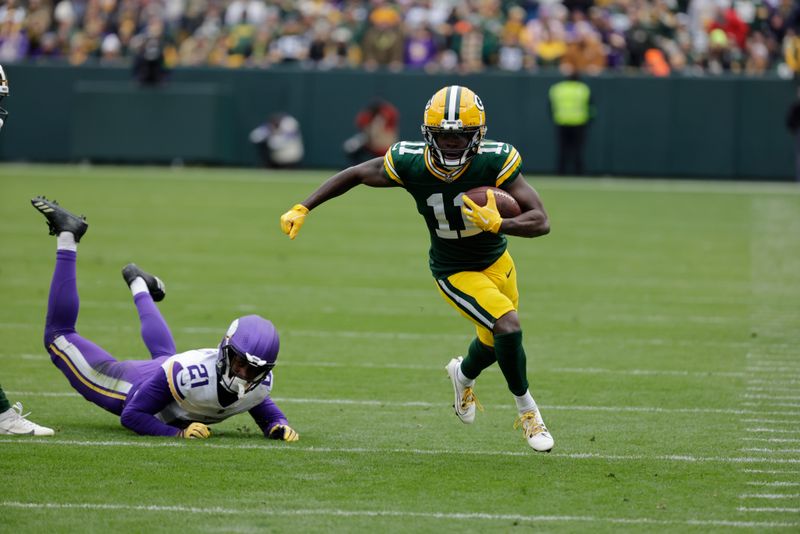 Green Bay Packers wide receiver Jayden Reed (11) tries to elude Minnesota Vikings cornerback Akayleb Evans (21) during an NFL football game Sunday, Oct. 29, 2023, in Green Bay, Wis. (AP Photo/Mike Roemer)