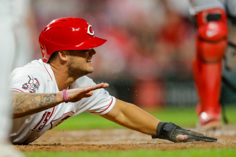 Sep 18, 2023; Cincinnati, Ohio, USA; Cincinnati Reds pinch hitter Nick Senzel (15) slides home on a two-run single hit by first baseman Joey Votto (not pictured) in the seventh inning in the game against the Minnesota Twins at Great American Ball Park. Mandatory Credit: Katie Stratman-USA TODAY Sports