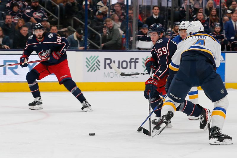 Dec 8, 2023; Columbus, Ohio, USA; Columbus Blue Jackets right wing Yegor Chinakhov (59) chips the puck past St. Louis Blues defenseman Nick Leddy (4) during the second period at Nationwide Arena. Mandatory Credit: Russell LaBounty-USA TODAY Sports