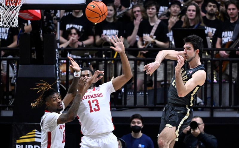 Jan 13, 2023; West Lafayette, Indiana, USA;  Purdue Boilermakers guard Ethan Morton (25) passes the ball away from Nebraska Cornhuskers guard Denim Dawson (12) and forward Derrick Walker (13) during the first half at Mackey Arena. Mandatory Credit: Marc Lebryk-USA TODAY Sports