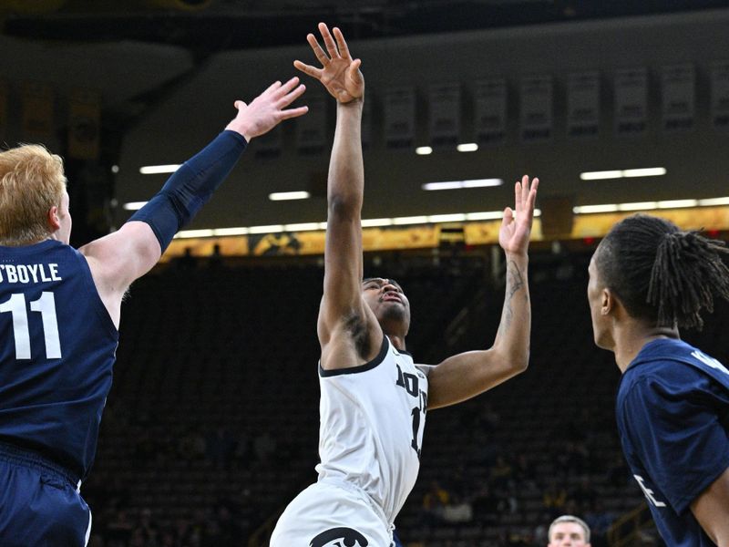 Feb 27, 2024; Iowa City, Iowa, USA; Iowa Hawkeyes guard Tony Perkins (11) shoots the ball as Penn State Nittany Lions forward Leo O'Boyle (11) and guard Nick Kern Jr. (3) defend during the second half at Carver-Hawkeye Arena. Mandatory Credit: Jeffrey Becker-USA TODAY Sports