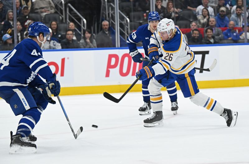 Oct 25, 2025; Toronto, Ontario, CAN; Buffalo Sabres defenceman Rasmus Dahlin (26) shoots the puck past Toronto Maple Leafs defenceman Morgan Rielly (44) in overtime at Scotiabank Arena. Mandatory Credit: Gerry Angus-Imagn Images