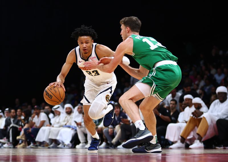 ABU DHABI, UNITED ARAB EMIRATES - OCTOBER 06: Trey Alexander of Denver Nuggets drives to the basket against Drew Peterson of Boston Celtics during the NBA match between Boston Celtics  and Denver Nuggets at Etihad Arena on October 06, 2024 in Abu Dhabi, United Arab Emirates.  (Photo by Francois Nel/Getty Images)