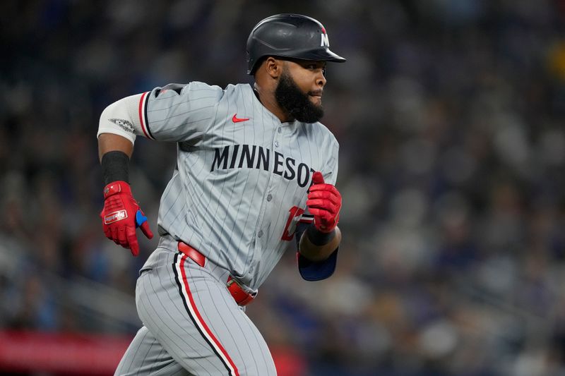 May 10, 2024; Toronto, Ontario, CAN; Minnesota Twins right fielder Manuel Margot (13) runs to first base on a single against the Toronto Blue Jays during the ninth inning at Rogers Centre. Mandatory Credit: John E. Sokolowski-USA TODAY Sports