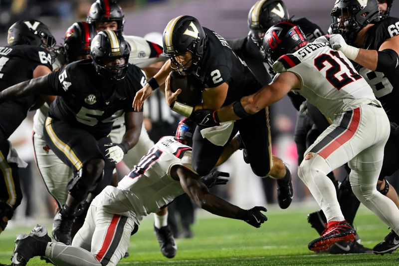 Oct 19, 2024; Nashville, Tennessee, USA;  Vanderbilt Commodores quarterback Diego Pavia (2) leaps over Ball State Cardinals defensive back Willizhuan Yates (20) during the second half at FirstBank Stadium. Mandatory Credit: Steve Roberts-Imagn Images