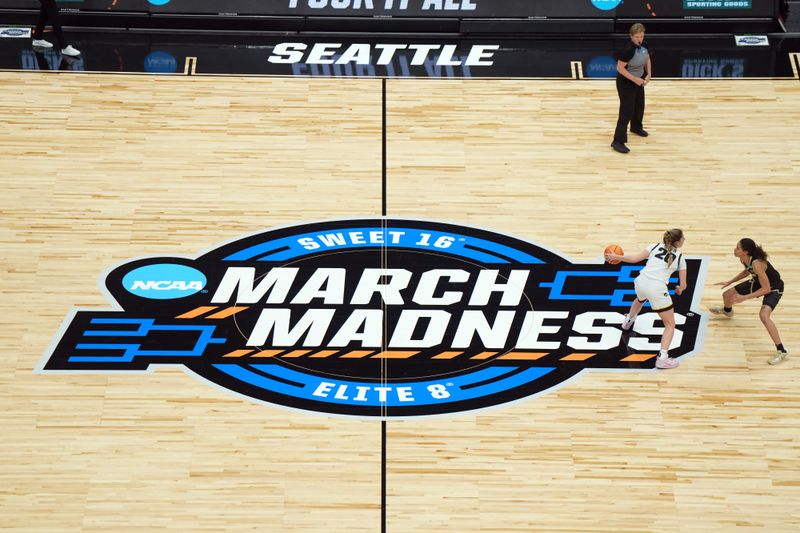 Mar 24, 2023; Seattle, WA, USA; A general overall view as Iowa Hawkeyes guard Kate Martin (20) dribbles the ball against Colorado Buffaloes guard Tayanna Jones (1) on the March Madness logo at center court in the first half at Climate Pledge Arena. Mandatory Credit: Kirby Lee-USA TODAY Sports