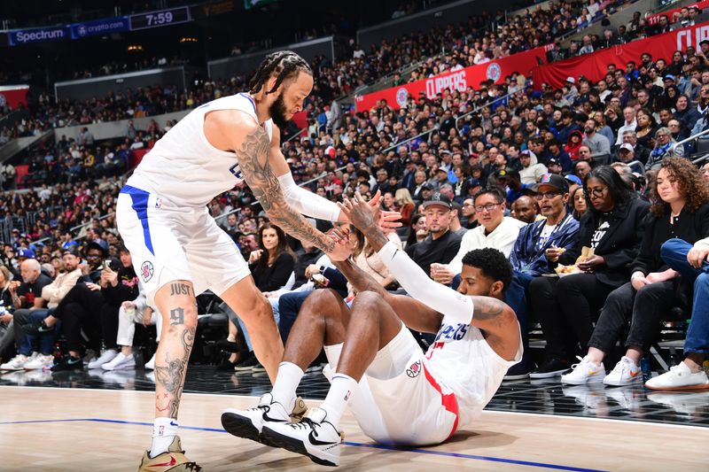 LOS ANGELES, CA - APRIL 4: Amir Coffey #7 helps up Paul George #13 of the LA Clippers during the game against the Denver Nuggets on April 4, 2024 at Crypto.Com Arena in Los Angeles, California. NOTE TO USER: User expressly acknowledges and agrees that, by downloading and/or using this Photograph, user is consenting to the terms and conditions of the Getty Images License Agreement. Mandatory Copyright Notice: Copyright 2024 NBAE (Photo by Adam Pantozzi/NBAE via Getty Images)