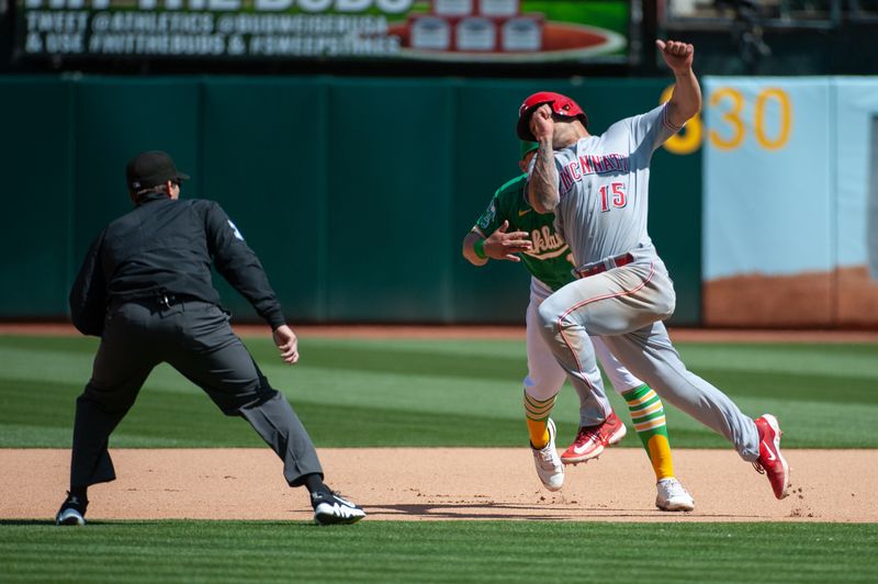 Apr 29, 2023; Oakland, California, USA; Cincinnati Reds center fielder Nick Senzel (15) attempts to avoid the tag by Oakland Athletics second baseman Jordan Diaz (13) during the seventh inning at RingCentral Coliseum. Mandatory Credit: Ed Szczepanski-USA TODAY Sports