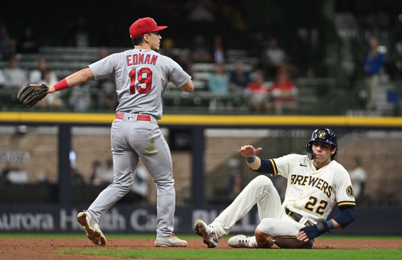 Sep 28, 2023; Milwaukee, Wisconsin, USA; St. Louis Cardinals shortstop Tommy Edman (19) forces out Milwaukee Brewers left fielder Christian Yelich (22) and completes the double play in the fifth inning at American Family Field. Mandatory Credit: Michael McLoone-USA TODAY Sports