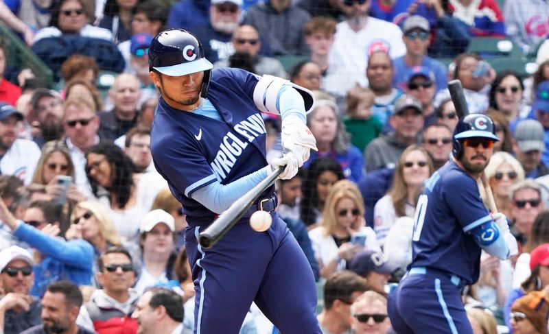 Jun 16, 2023; Chicago, Illinois, USA; Chicago Cubs right fielder Seiya Suzuki (27) hits a one run single against the Baltimore Orioles during the sixth inning at Wrigley Field. Mandatory Credit: David Banks-USA TODAY Sports