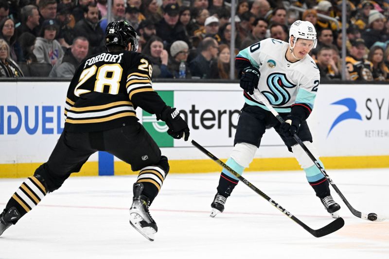 Feb 15, 2024; Boston, Massachusetts, USA; Seattle Kraken right wing Eeli Tolvanen (20) passes the puck in front of Boston Bruins defenseman Derek Forbort (28) during the second period at the TD Garden. Mandatory Credit: Brian Fluharty-USA TODAY Sports