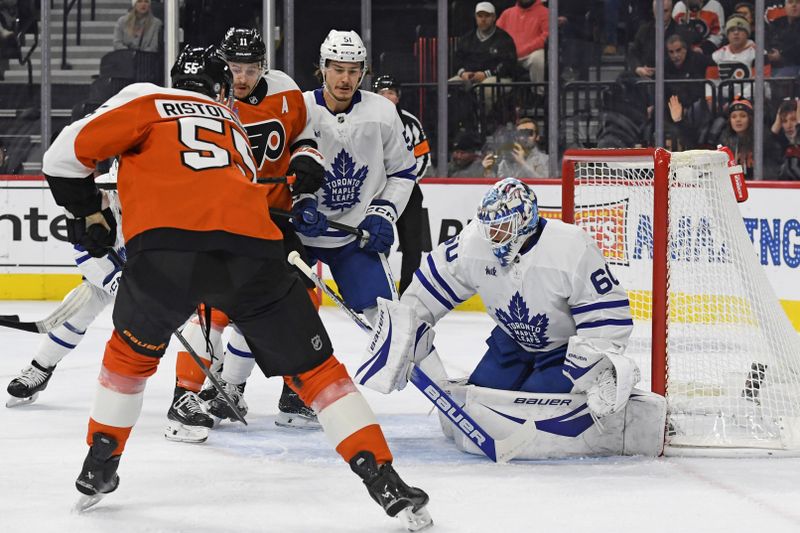 Jan 7, 2025; Philadelphia, Pennsylvania, USA; Toronto Maple Leafs goaltender Joseph Woll (60) makes a save against Philadelphia Flyers defenseman Rasmus Ristolainen (55) during the first period at Wells Fargo Center. Mandatory Credit: Eric Hartline-Imagn Images