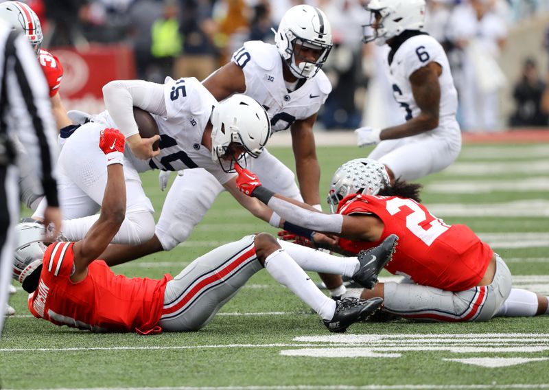 Oct 21, 2023; Columbus, Ohio, USA; Ohio State Buckeyes linebacker Steele Chambers (22) tackles Penn State Nittany Lions quarterback Drew Allar (15) by the face mask by during the fourth quarter at Ohio Stadium. Mandatory Credit: Joseph Maiorana-USA TODAY Sports