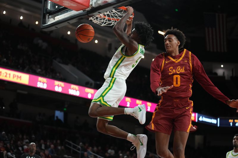 Feb 21, 2026; Los Angeles, California, USA; Oregon Ducks guard Takai Simpkins (5) dunks the ball against Southern California Trojans guard Alijah Arenas (0) in the first half at Galen Center. Mandatory Credit: Kirby Lee-Imagn Images