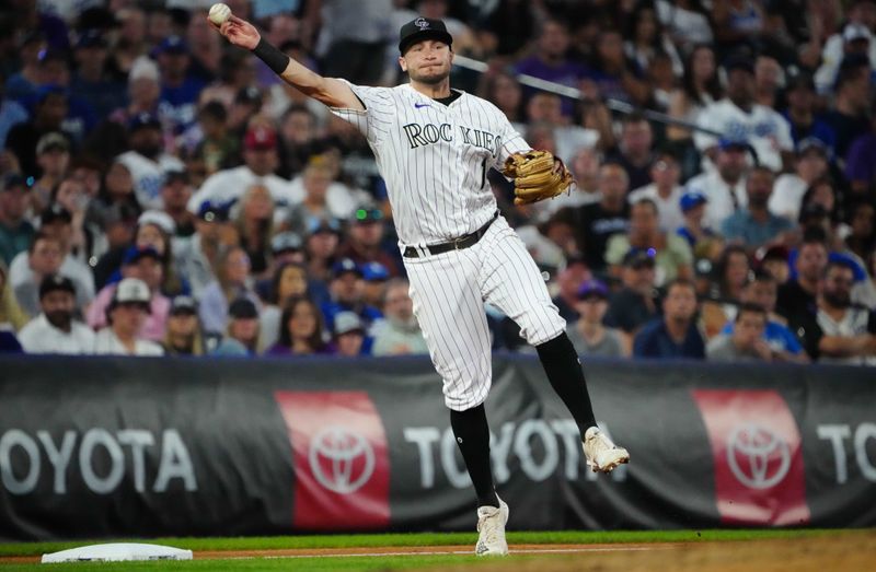 Jul 30, 2022; Denver, Colorado, USA; Colorado Rockies third basemen Garrett Hampson (1) field the ball in the seventh inning against the Los Angeles Dodgers at Coors Field. Mandatory Credit: Ron Chenoy-USA TODAY Sports