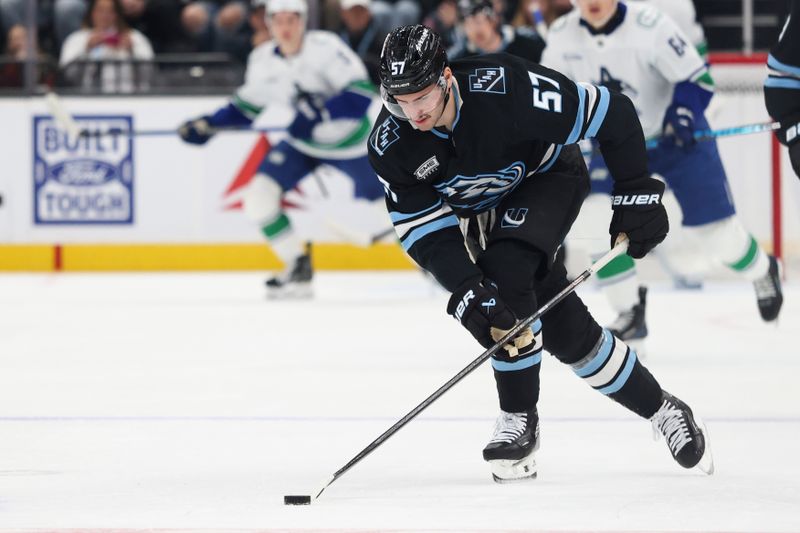 Feb 2, 2026; Salt Lake City, Utah, USA; Utah Mammoth defenseman Nick DeSimone (57) controls the puck during the first period of the game against the Vancouver Canucks at Delta Center. Mandatory Credit: Rob Gray-Imagn Images