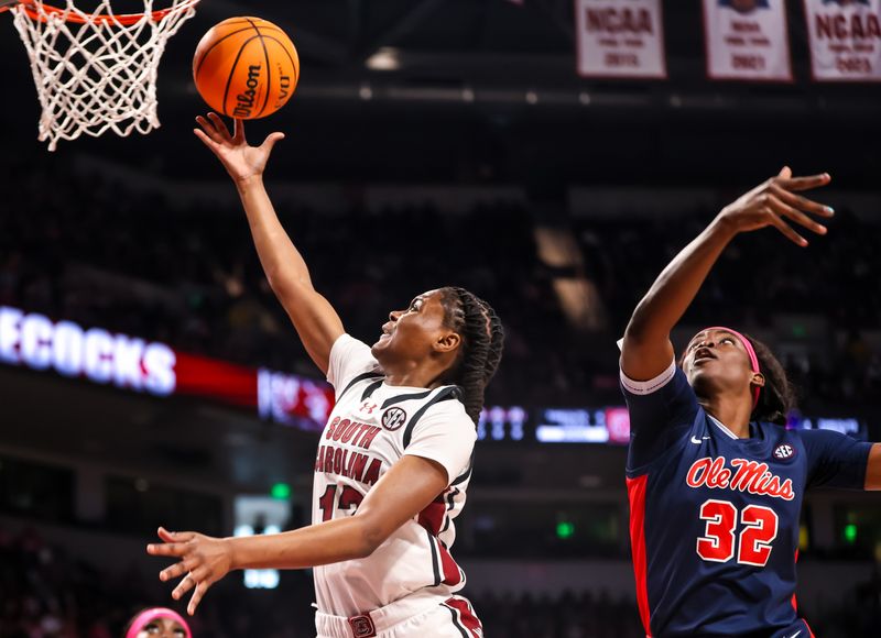 Feb 4, 2024; Columbia, South Carolina, USA; South Carolina Gamecocks guard MiLaysia Fulwiley (12) drives around Ole Miss Rebels center Rita Igbokwe (32) in the first half at Colonial Life Arena. Mandatory Credit: Jeff Blake-USA TODAY Sports