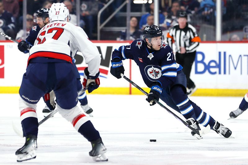 Mar 11, 2024; Winnipeg, Manitoba, CAN; Winnipeg Jets left wing Nikolaj Ehlers (27) skates up the ice to Washington Capitals defenseman Alexander Alexeyev (27) in the second period at Canada Life Centre. Mandatory Credit: James Carey Lauder-USA TODAY Sports