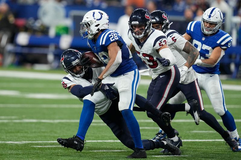 Indianapolis Colts running back Jonathan Taylor (28) is tackled by Houston Texans safety DeAndre Houston-Carson, left, during the first half of an NFL football game Saturday, Jan. 6, 2024, in Indianapolis. (AP Photo/Darron Cummings)