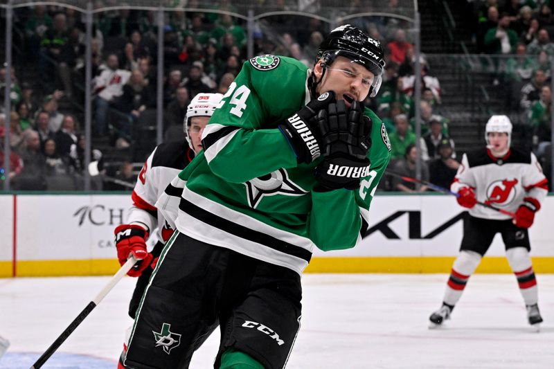 Mar 4, 2025; Dallas, Texas, USA; Dallas Stars center Roope Hintz (24) reacts to getting hit by the high stick of New Jersey Devils left wing Erik Haula (56) during the second period at the American Airlines Center. Mandatory Credit: Jerome Miron-Imagn Images