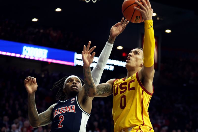 Jan 17, 2024; Tucson, Arizona, USA; USC Trojans guard Kobe Johnson (0) drives to the net against Arizona Wildcats guard Caleb Love (2) during the first half at McKale Center. Mandatory Credit: Zachary BonDurant-USA TODAY Sports