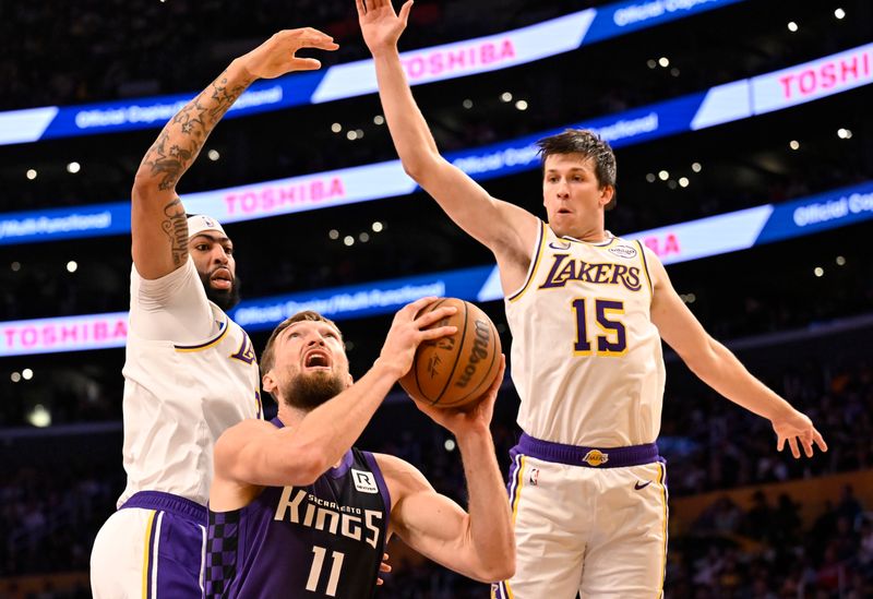 LOS ANGELES, CALIFORNIA - OCTOBER 26: Anthony Davis #3 of the Los Angeles Lakers and Austin Reaves #15  guard Domantas Sabonis #11 of the Sacramento Kings in the first half at Crypto.com Arena on October 26, 2024 in Los Angeles, California. NOTE TO USER: User expressly acknowledges and agrees that, by downloading and or using this photograph, User is consenting to the terms and conditions of the Getty Images License Agreement. (Photo by John McCoy/Getty Images)