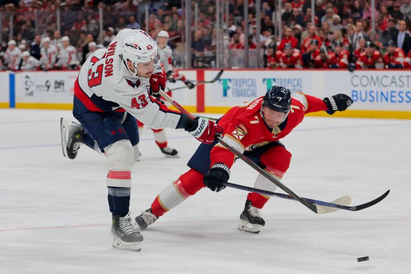 Nov 25, 2024; Sunrise, Florida, USA; Washington Capitals right wing Tom Wilson (43) shoots the puck as Florida Panthers defenseman Dmitry Kulikov (7) defends during the first period at Amerant Bank Arena. Mandatory Credit: Sam Navarro-Imagn Images