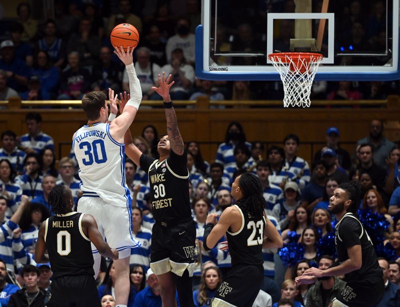 Feb 12, 2024; Durham, North Carolina, USA;  Duke Blue Devils center Kyle Filipowski (30) shooots over Wake Forest Deamon Deacons guard Damari Monsanto (30) during the first half at Cameron Indoor Stadium. Mandatory Credit: Rob Kinnan-USA TODAY Sports