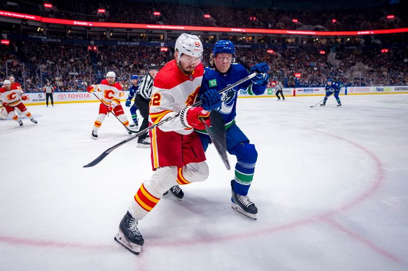 Apr 16, 2024; Vancouver, British Columbia, CAN; Calgary Flames defenseman MacKenzie Weegar (52) battles with Vancouver Canucks forward Brock Boeser (6) in the first period at Rogers Arena. Mandatory Credit: Bob Frid-USA TODAY Sports