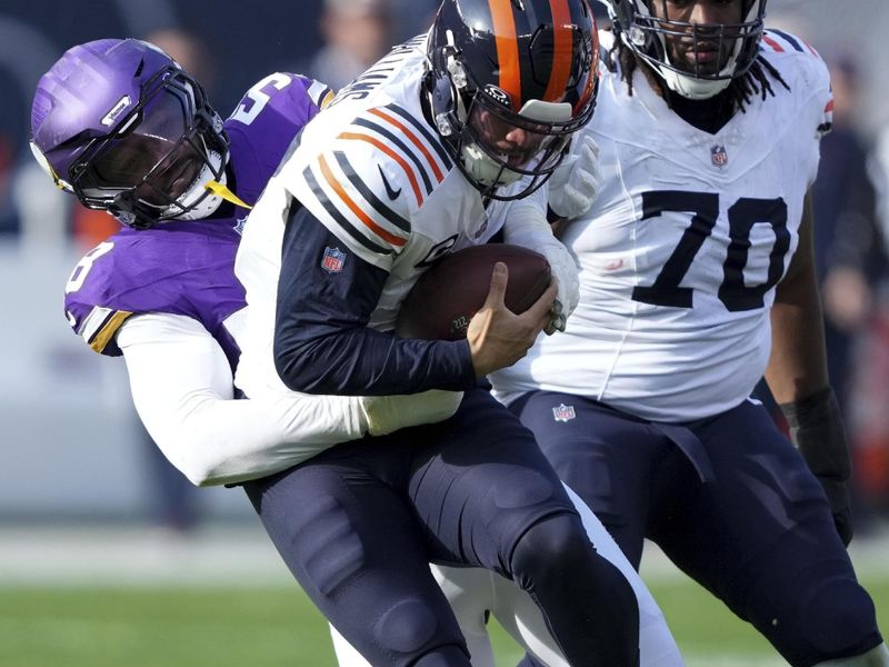 Chicago Bears quarterback Caleb Williams is sacked by Minnesota Vikings linebacker Jonathan Greenard (58) during the first half of an NFL football game Sunday, Nov. 24, 2024, in Chicago. (AP Photo/Charles Rex Arbogast)