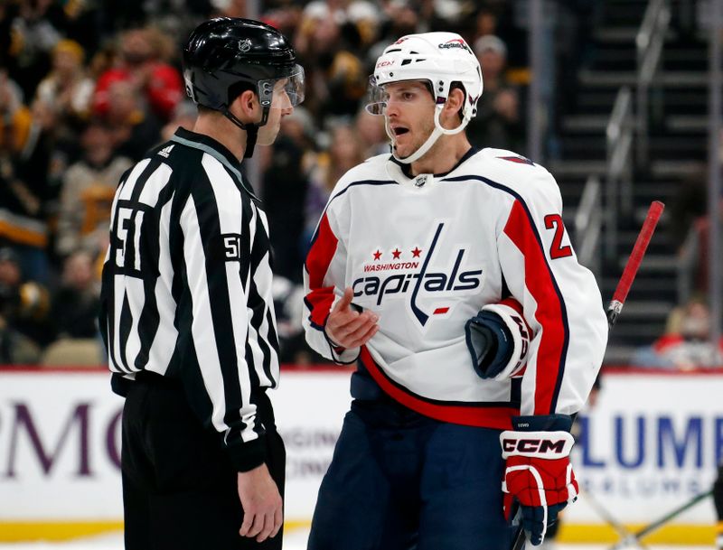 Jan 2, 2024; Pittsburgh, Pennsylvania, USA;  NHL linesman Andrew Smith (51) listens to Washington Capitals right wing Nic Dowd (26) against the Pittsburgh Penguins during the second period at PPG Paints Arena. Mandatory Credit: Charles LeClaire-USA TODAY Sports