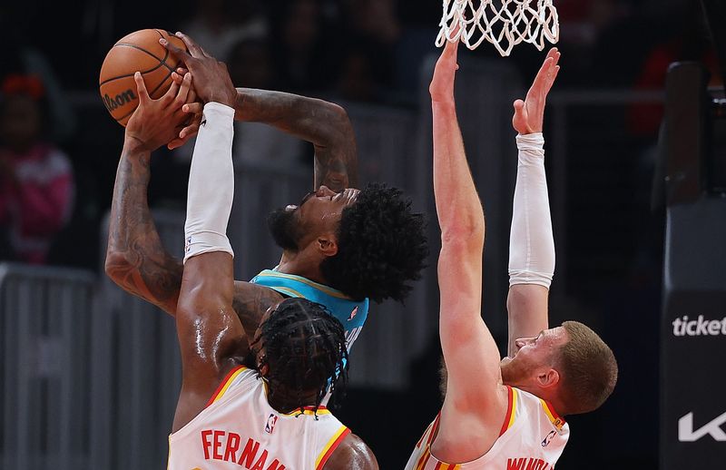 ATLANTA, GEORGIA - MARCH 23:  Dylan Windler #20 of the Atlanta Hawks defends as Bruno Fernando #24 blocks a shot by Nick Richards #4 of the Charlotte Hornets during the second quarter at State Farm Arena on March 23, 2024 in Atlanta, Georgia.  NOTE TO USER: User expressly acknowledges and agrees that, by downloading and/or using this photograph, user is consenting to the terms and conditions of the Getty Images License Agreement.  (Photo by Kevin C. Cox/Getty Images)