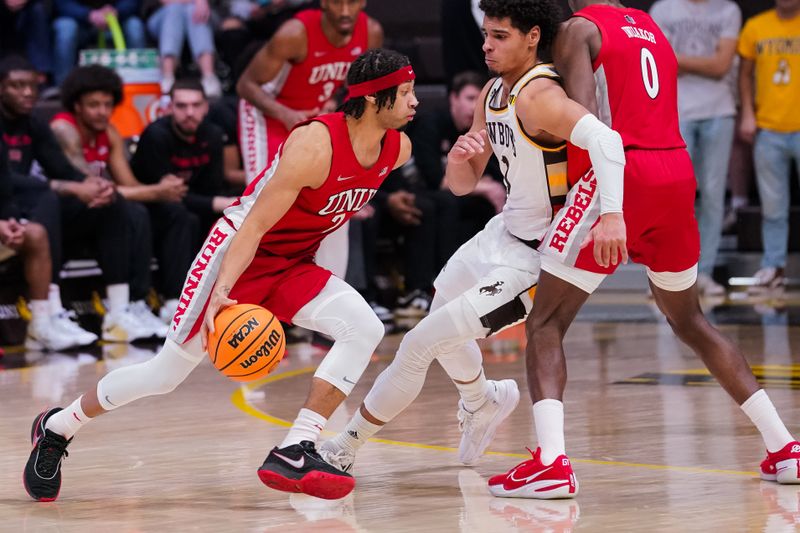 Feb 8, 2023; Laramie, Wyoming, USA; UNLV Runnin' Rebels guard Justin Webster (2) drives against Wyoming Cowboys guard Brendan Wenzel (1) during the second half at Arena-Auditorium. Mandatory Credit: Troy Babbitt-USA TODAY Sports