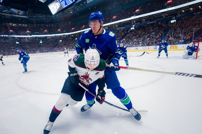 Jan 18, 2024; Vancouver, British Columbia, CAN; Vancouver Canucks defenseman Nikita Zadorov (91) checks Arizona Coyotes forward Clayton Keller (9) in the first period at Rogers Arena. Mandatory Credit: Bob Frid-USA TODAY Sports