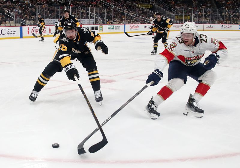 Dec 3, 2024; Pittsburgh, Pennsylvania, USA;  Pittsburgh Penguins defenseman Marcus Pettersson (28) and Florida Panthers center Carter Verhaeghe (23) reach for the puck during the second period at PPG Paints Arena. Mandatory Credit: Charles LeClaire-Imagn Images